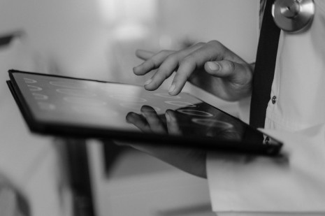 grayscale photo of a doctor using a digital tablet